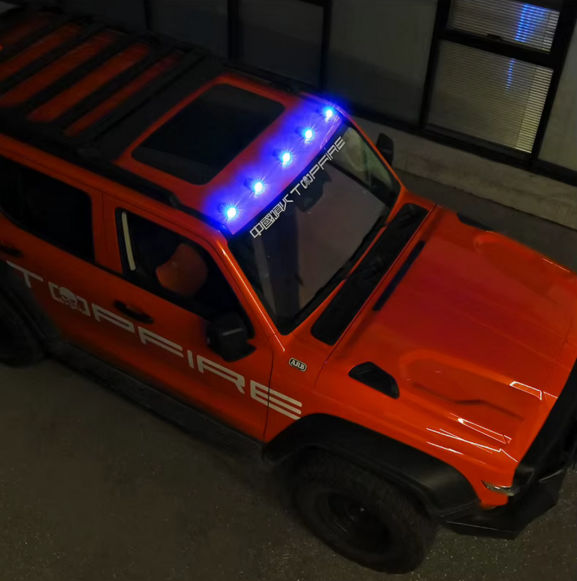 4x4 tout-terrain orange vu de dessus, équipé de phares bleus sur le toit